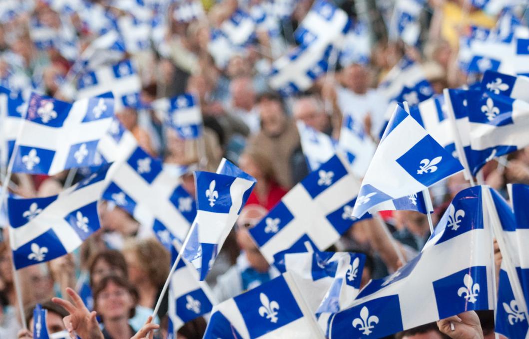 Foule en fête agitant le drapeau du Québec